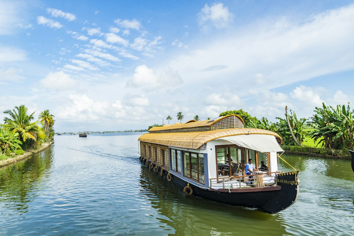 Expansive Vembanad Lake backwaters in Kottayam Kerala with traditional houseboats and palm-lined shores